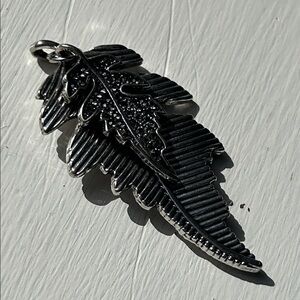 Double leaf silver toned pendant with purple rhinestones